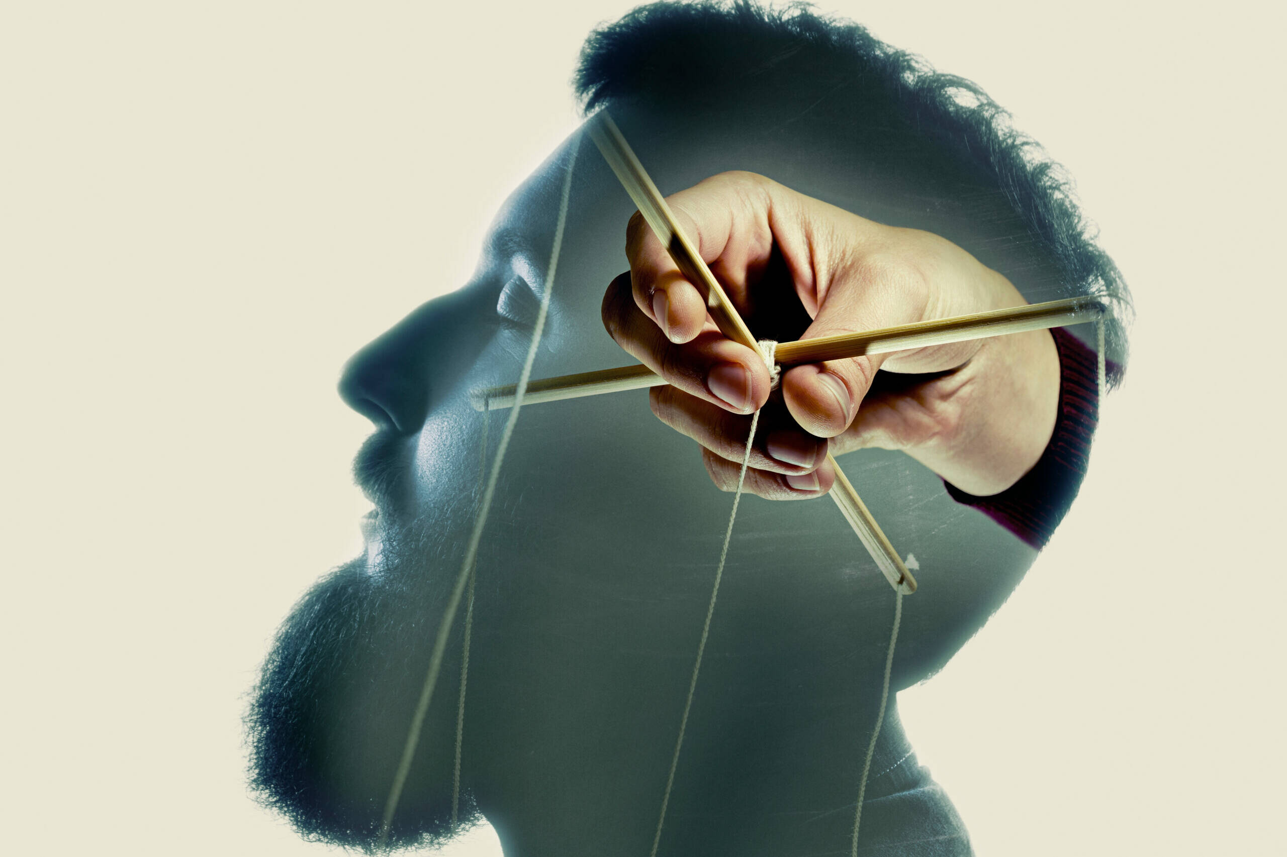 Illustration représentant une main tenant les fils d'une marionnette devant le profil d'un visage. Ce visuel symbolise les stratégies de contrôle que le cerveau met progressivement en place pour maintenir un sentiment de sécurité face à l'incertitude.