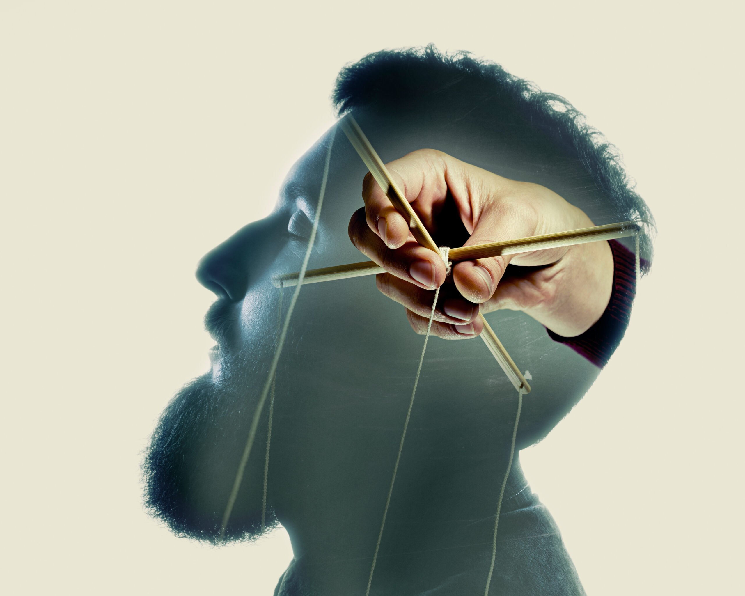 Illustration représentant une main tenant les fils d'une marionnette devant le profil d'un visage. Ce visuel symbolise les stratégies de contrôle que le cerveau met progressivement en place pour maintenir un sentiment de sécurité face à l'incertitude.