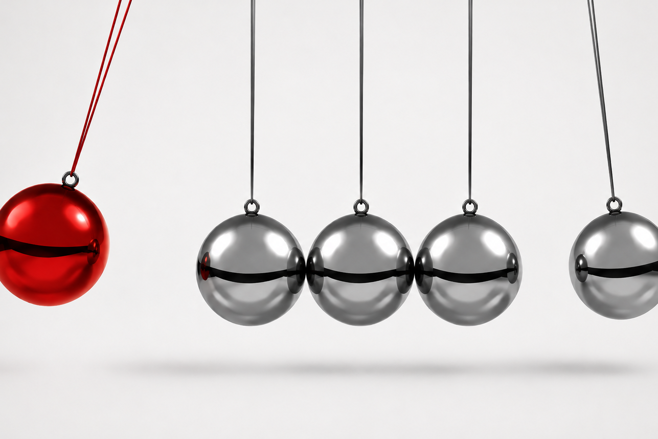Pendule de Newton avec une bille rouge transmettant son mouvement à plusieurs billes métalliques.