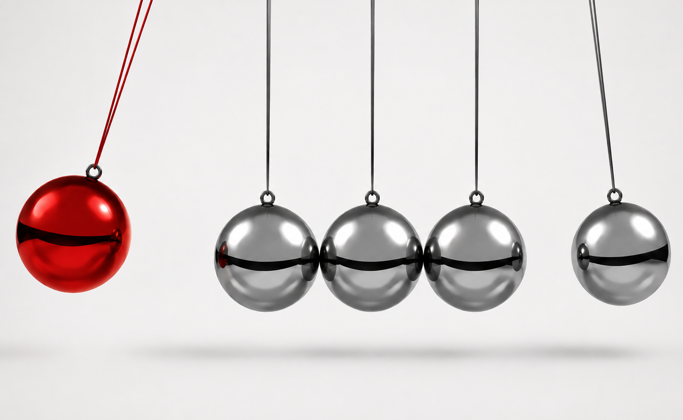 Pendule de Newton avec une bille rouge transmettant son mouvement à plusieurs billes métalliques.